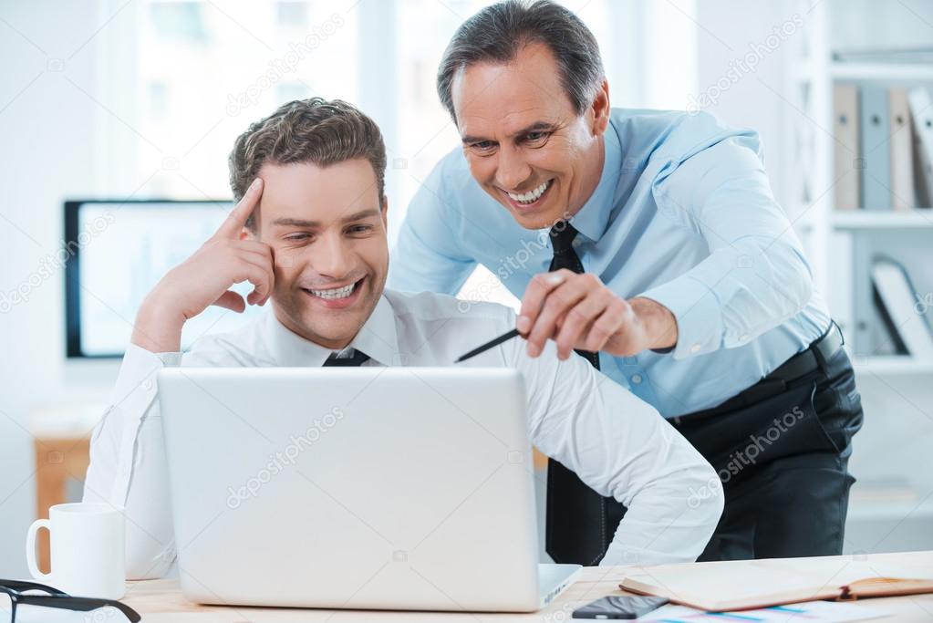 Business people looking at laptop