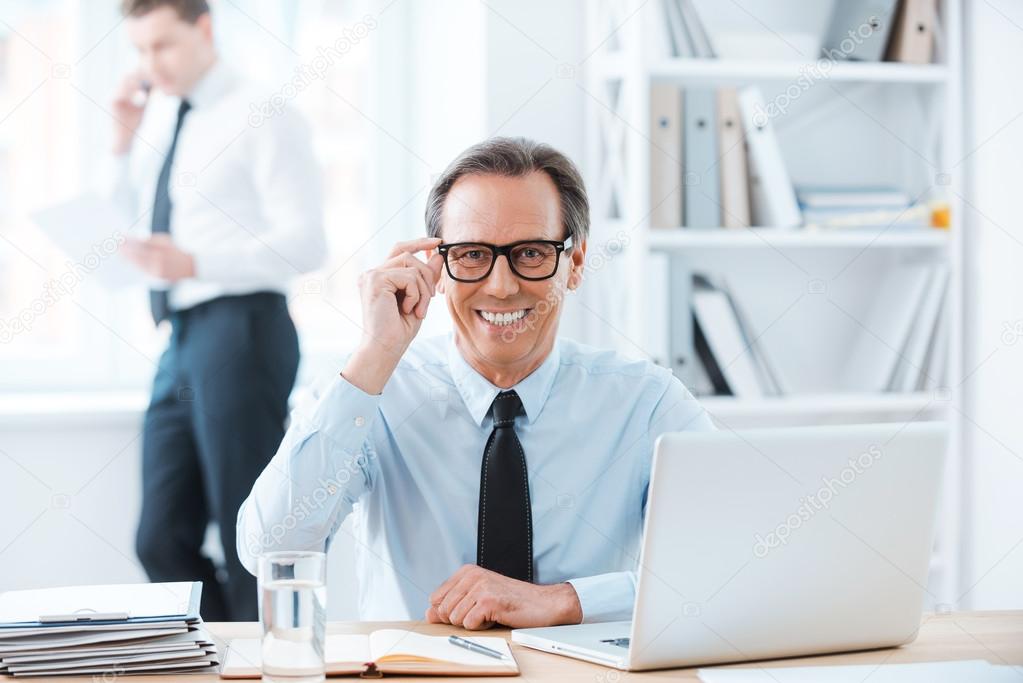 Businessman in formalwear adjusting eyewear