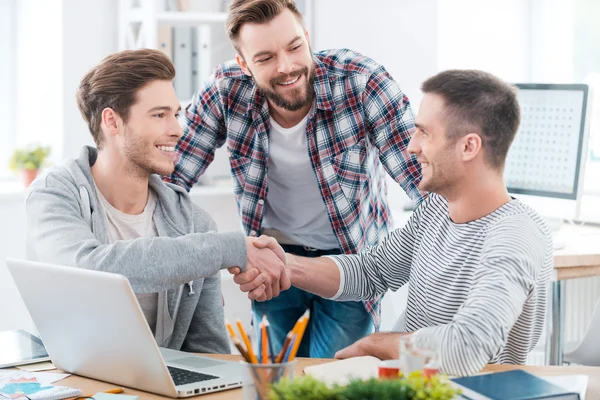 Des hommes assis au bureau et serrant la main — Photo