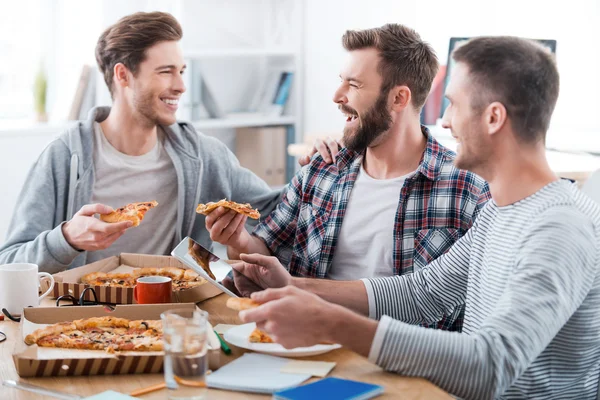 Mladí muži, jíst pizzu v úřadu — Stock fotografie