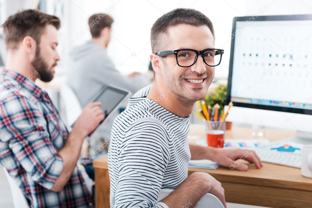 Man sitting at desk with colleagues