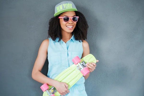 Afrikaanse vrouw bedrijf kleurrijke skateboard — Stockfoto