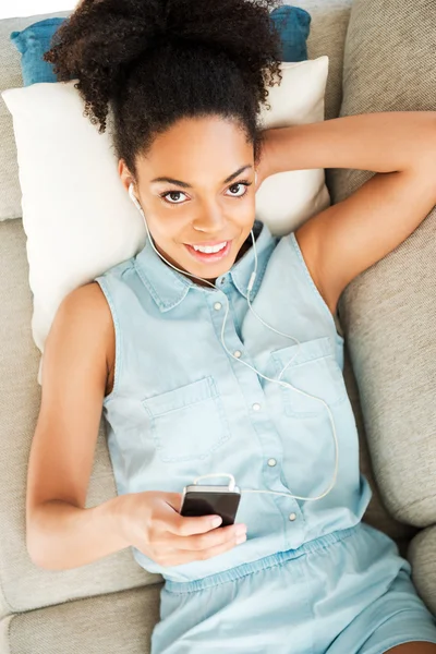 African woman in headphones listening to music — Stock Photo, Image