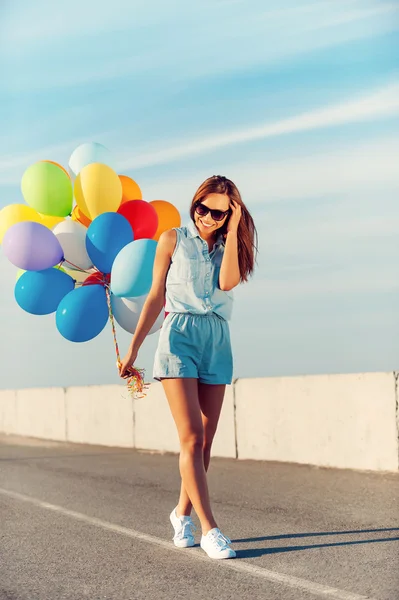 Mujer sosteniendo globos de colores — Foto de Stock