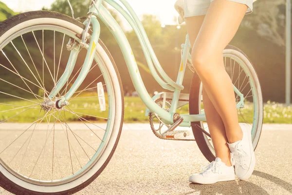 Mulher de pé perto de bicicleta — Fotografia de Stock