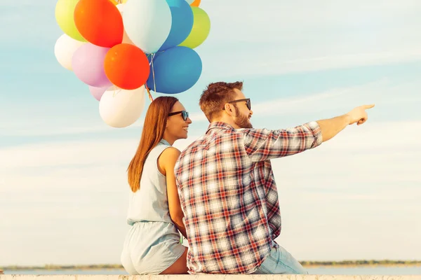 Jovem casal com balões coloridos — Fotografia de Stock