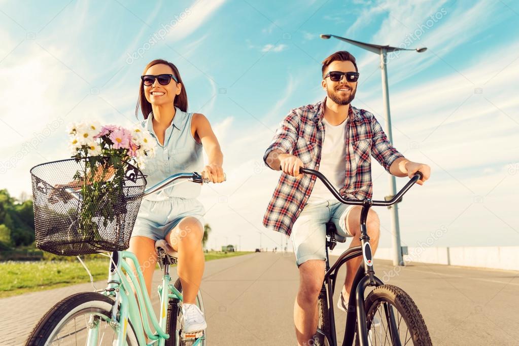 couple smiling and riding on bicycles
