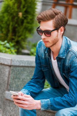 Kendine güvenen adam holding cep telefonu