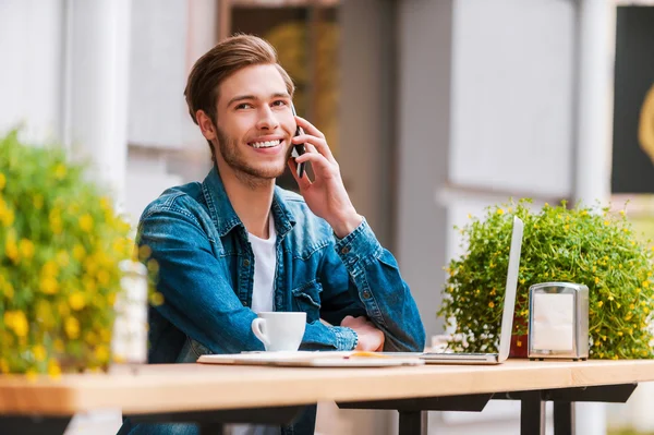 Man pratar i mobiltelefon på trottoarkafé — Stockfoto