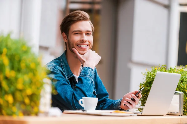 Man holding mobile at sidewalk cafe — Stock Photo, Image