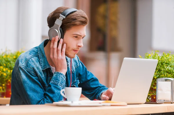 Homem em fones de ouvido trabalhando no laptop — Fotografia de Stock