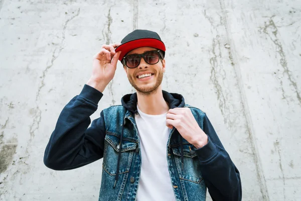 Man adjusting headwear and smiling — Stock Photo, Image