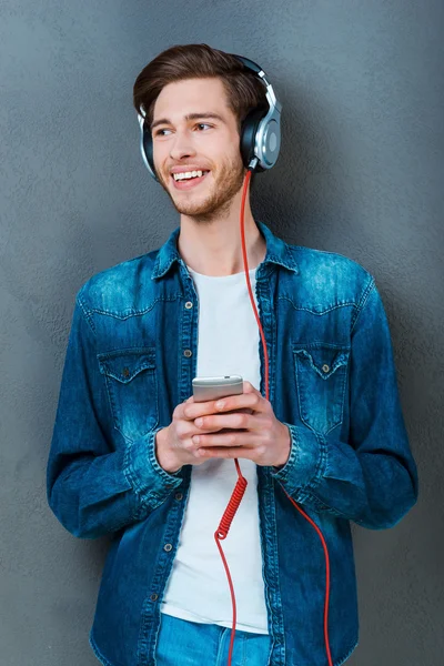 Man in headphones holding mobile phone — Stock Photo, Image