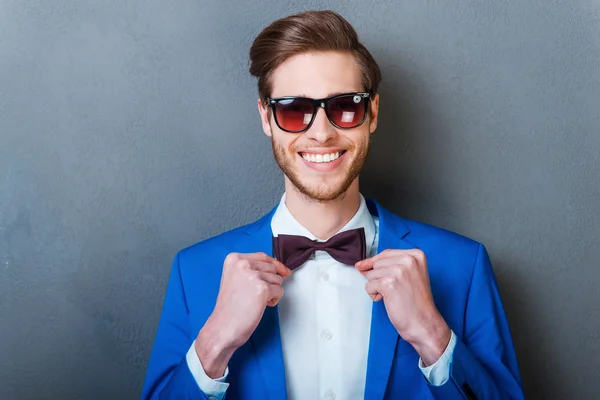 Man in eyewear adjusting bow tie — Stock Photo, Image