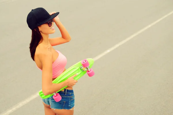 Woman holding her colorful skateboard — Stock Photo, Image