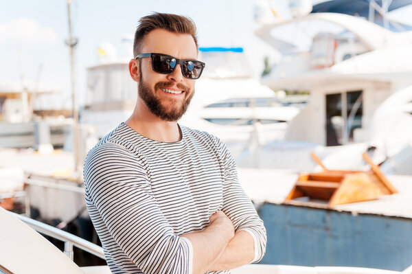 young man standing on board of yacht