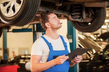 Pano holding ve araba inceleyerek adam