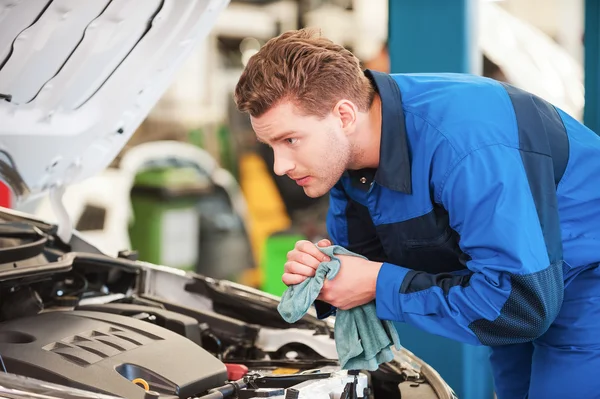 Man in uniform examining car — Stock Photo, Image