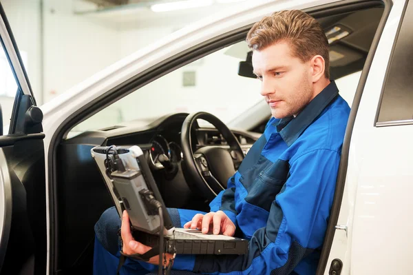 Uomo che lavora su laptop speciale in officina — Foto Stock