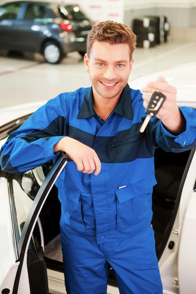 Man in uniform stretching out hand with keys — Stock Photo, Image