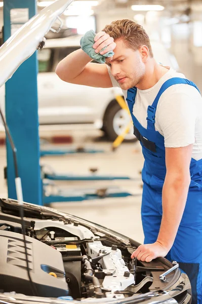 Homme examinant la voiture et essuyant le front — Photo