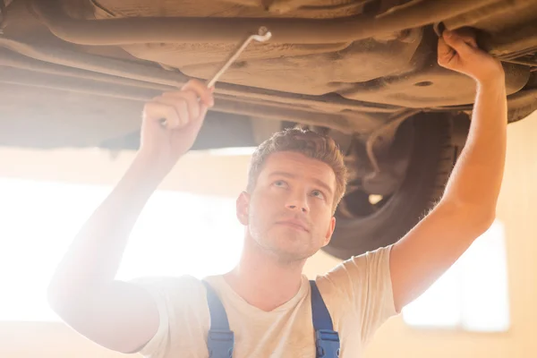 Homme réparer la voiture tout en étant debout dans l'atelier — Photo