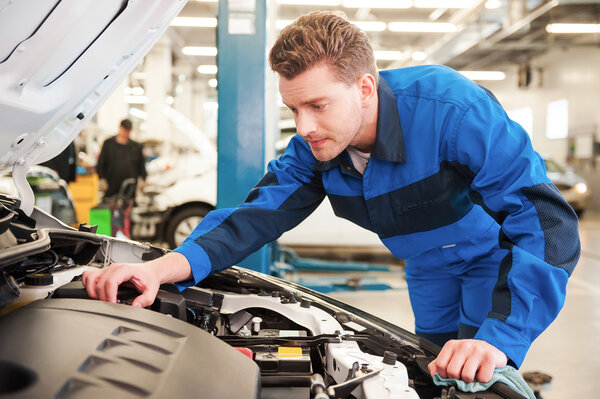 man in uniform repairing car