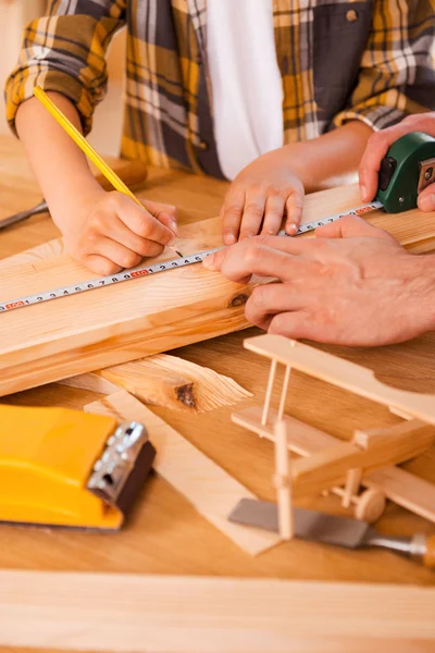 Jongen maken metingen op houten plank — Stockfoto