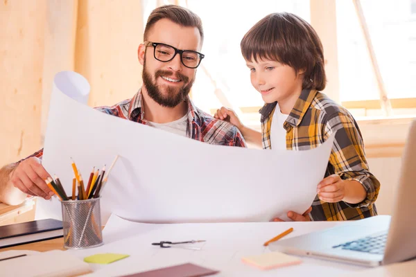 Man en zoon op zoek via blauwdruk — Stockfoto