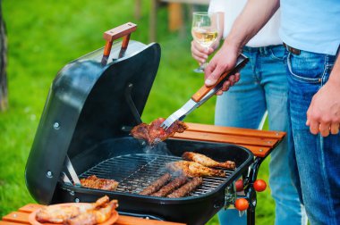 people barbecuing meat on the grill