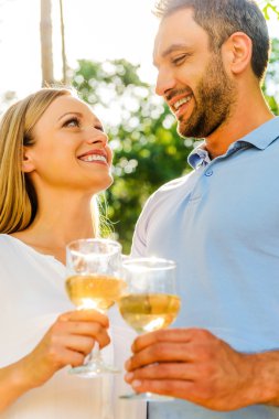 sevgi dolu çift gözlük şarap ile tutarak