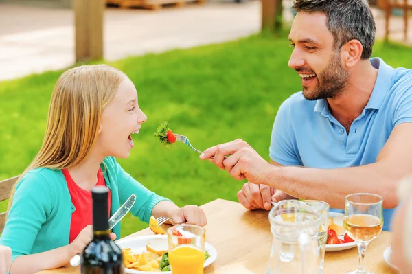 Mann füttert seine Tochter mit Salat — Stockfoto