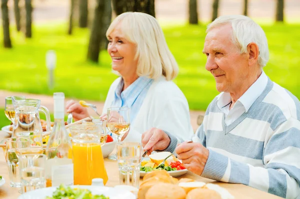 Pareja mayor disfrutando de la comida al aire libre — Foto de Stock