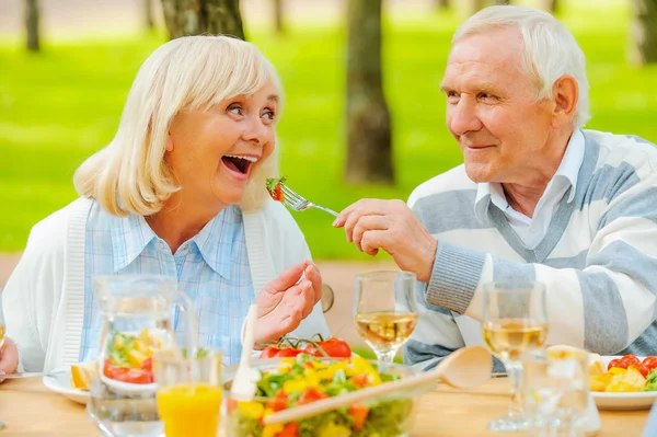 Äldre man mata hans trevliga fru — Stockfoto