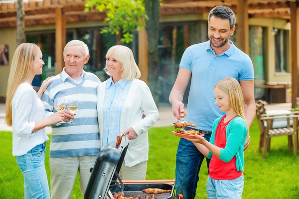 Familia feliz asar carne a la parrilla — Foto de Stock