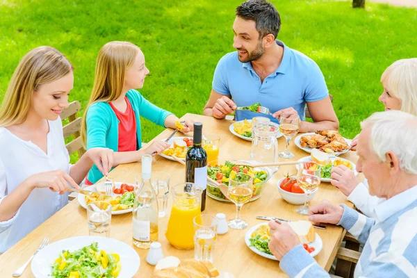 family enjoying meal outdoors - Stock Image - Everypixel