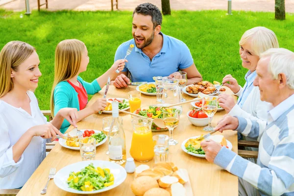 Glückliche Familie genießt Mahlzeit im Freien — Stockfoto