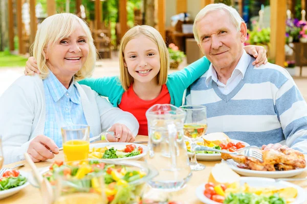 Chica abrazando a sus abuelos — Foto de Stock