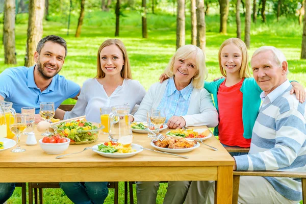 Familia sentada en la mesa de comedor al aire libre —  Fotos de Stock