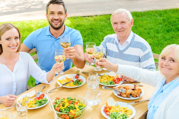 Familie aan de eettafel zitten — Stockfoto