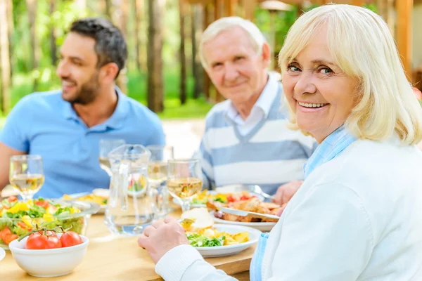 Familia sentada en la mesa de comedor al aire libre — Foto de Stock