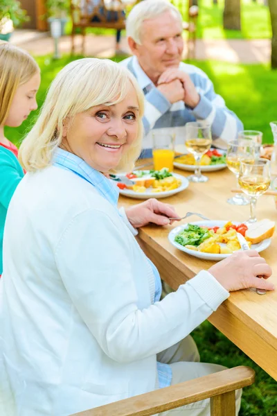 Mulher sênior desfrutando de jantar com a família — Fotografia de Stock