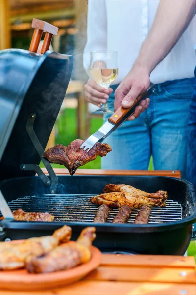 people barbecuing meat on grill