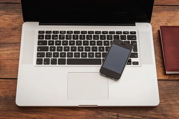 Aptop with mobile phone on desk — Stock Photo, Image