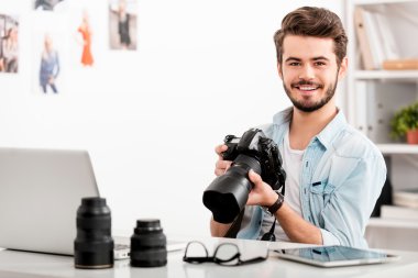 Neşeli adam holding dijital fotoğraf makinesi