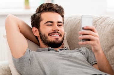 Sakallı adam cep telefonu tutan gülümseyerek
