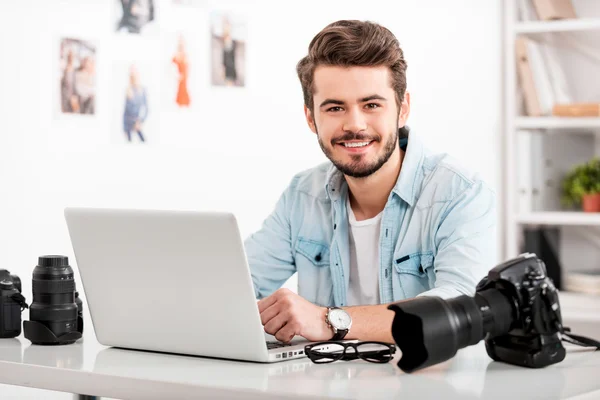 Lachende jonge man die op laptop werkt — Stockfoto