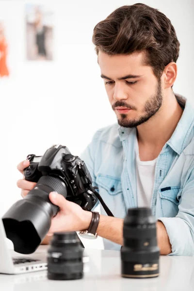 Serious young man holding camera — Stock Photo, Image