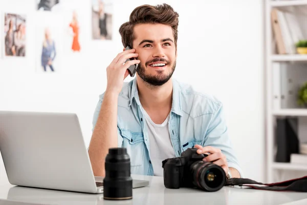 Uomo che parla al cellulare sul posto di lavoro — Foto Stock