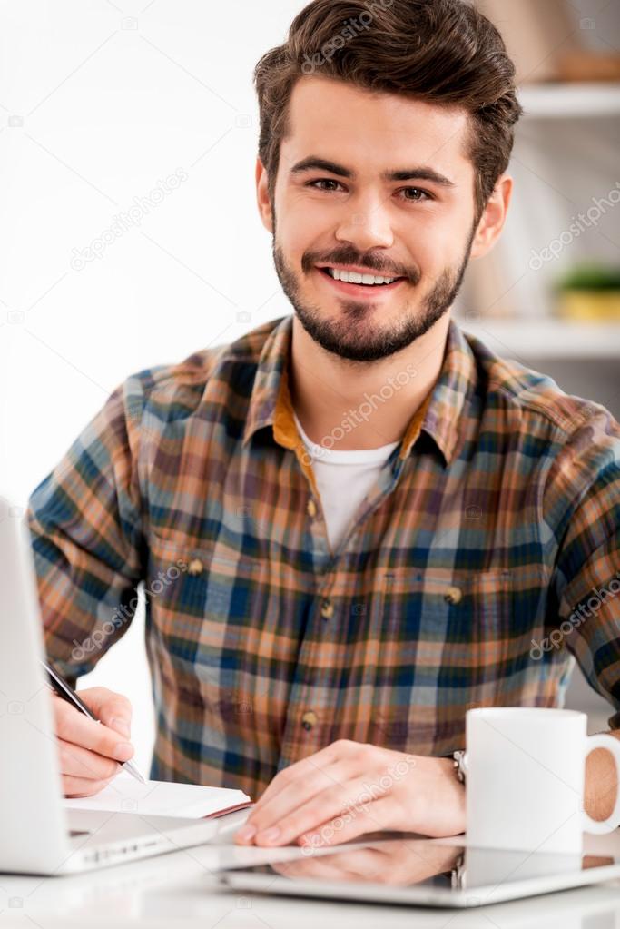 young man writing in note pad